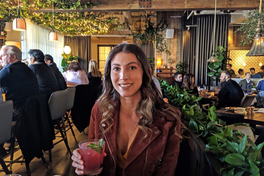 Girl holding drink at Aba restaurant in Chicago