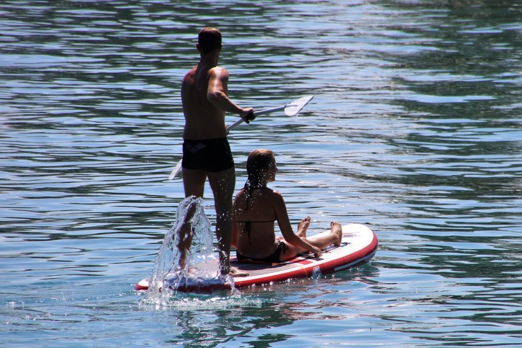 couple on one stand-up paddle board