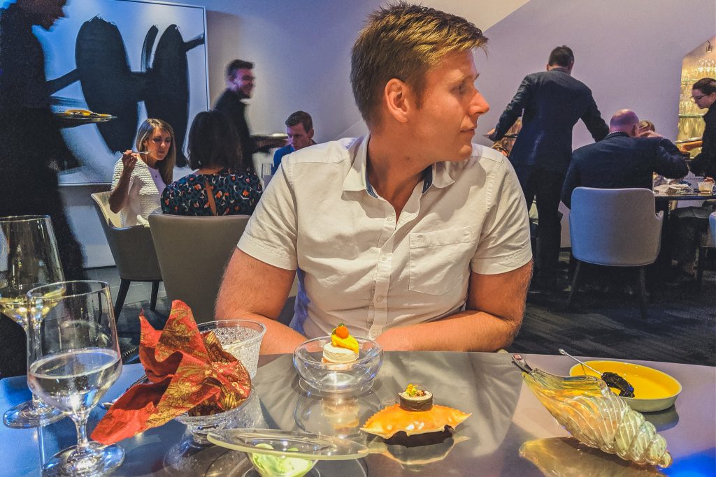 Man at Alinea with many plates in front of him