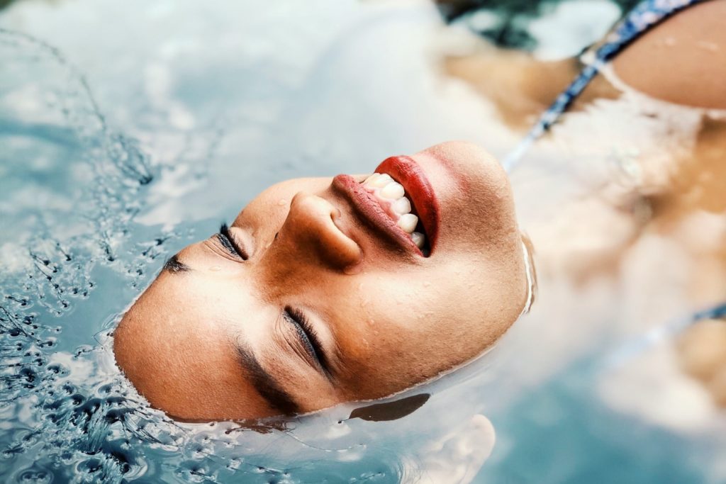woman 's face mostly submerged in water