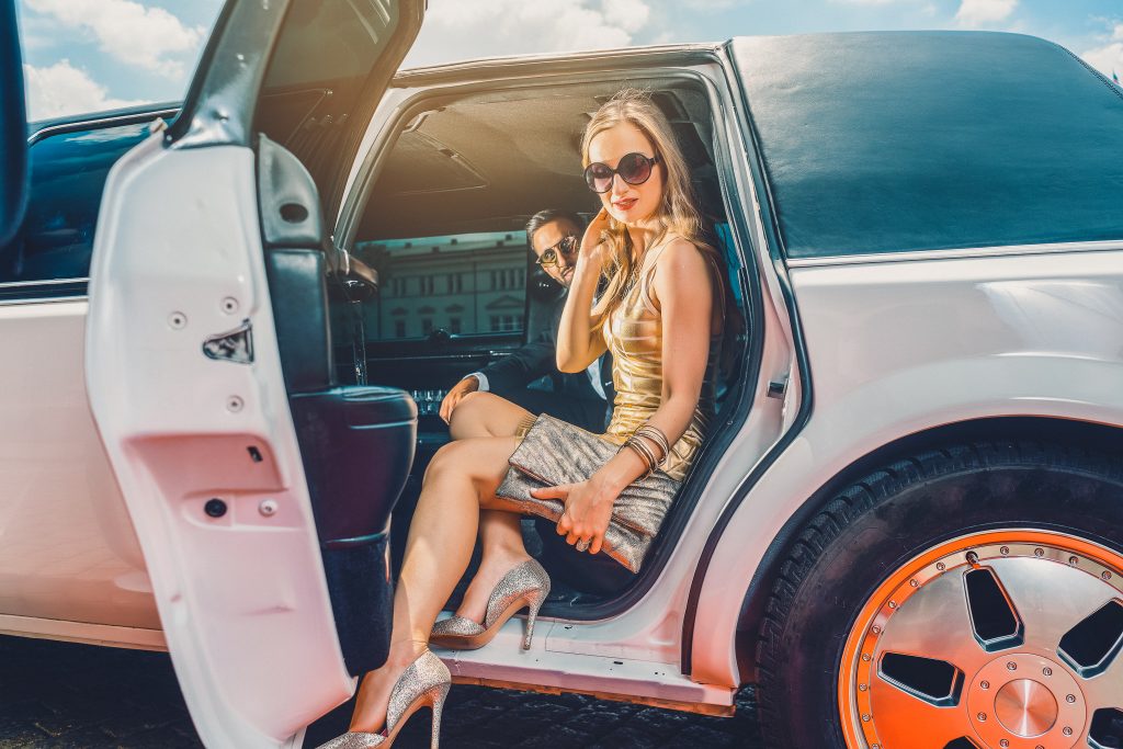 VIP Woman and man getting out of limousine with door being open