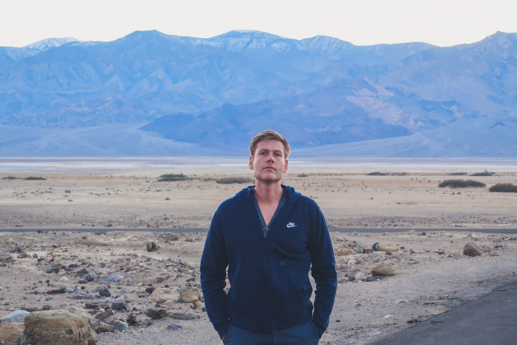 man at Death Valley National Park, blue mountains in the background