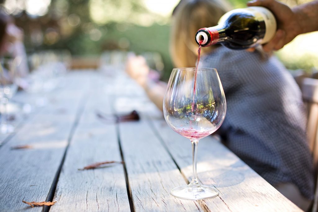 wine glass with small portion being poured inside for tasting