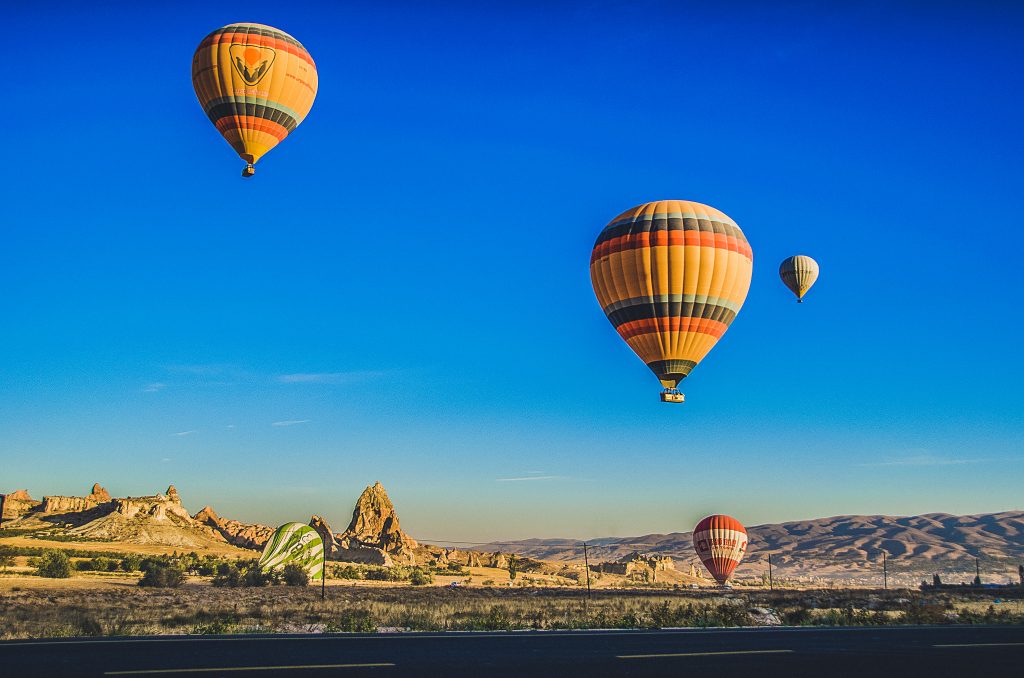 3 hot air baloons in the sky above the Nevada desert