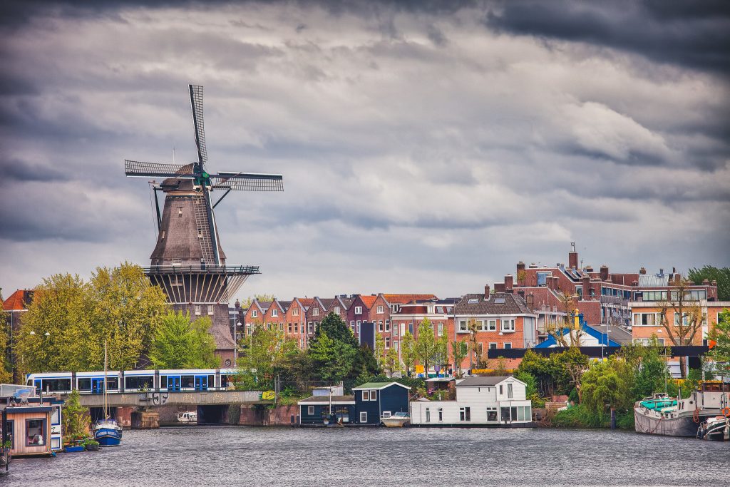 The Gooyer Windmill and houses by the canal, city of Amsterdam, North Holland, the Netherlands.