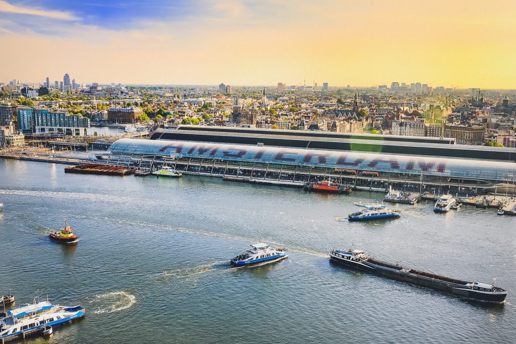 Amsterdam cityscape top view at sunset. River with ships, boats, Central station. From A'Dam lookout