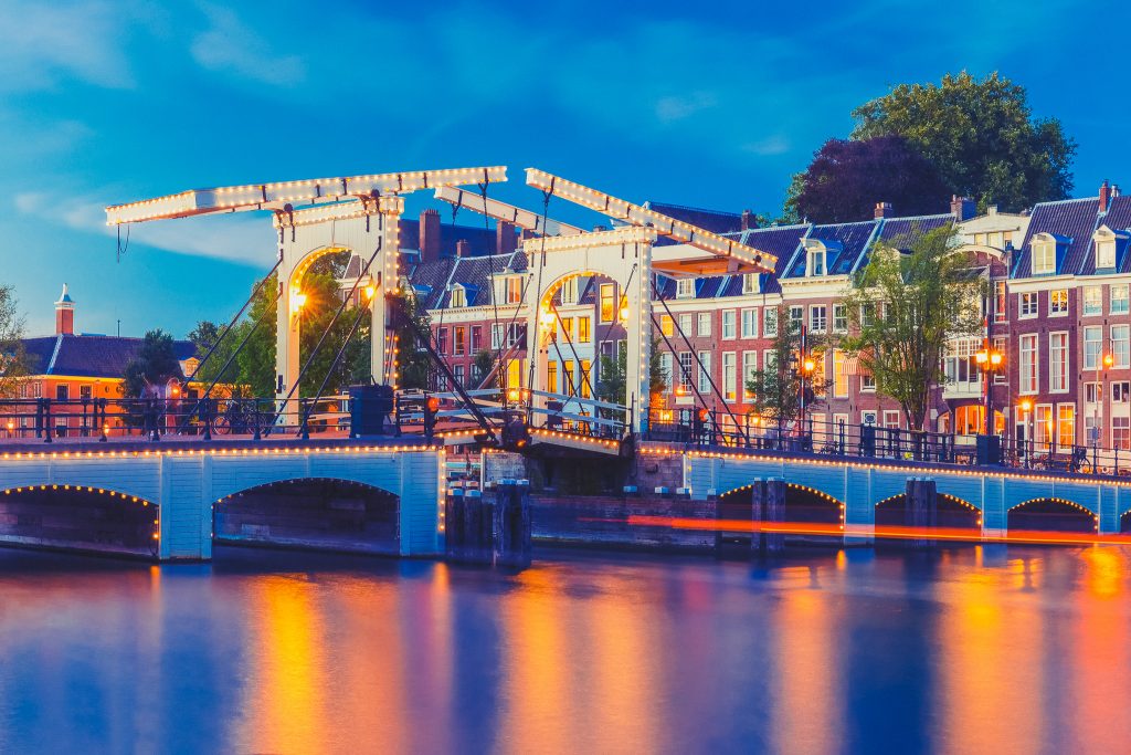 Magere Brug, Skinny bridge, with night lighting over the river Amstel in the city centre of Amsterdam, Holland, Netherlands. Used toning