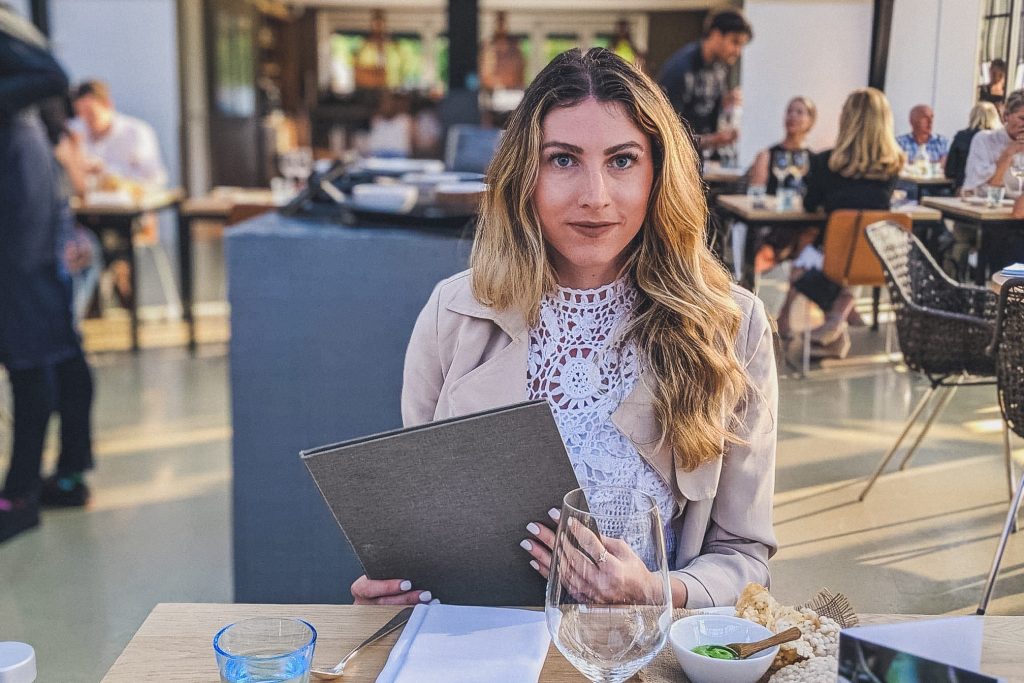 Chica sosteniendo el menú en el restaurante de kas en Ámsterdam