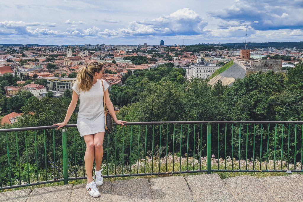 Girl looks out from hill of 3 crosses at city of Vilnius