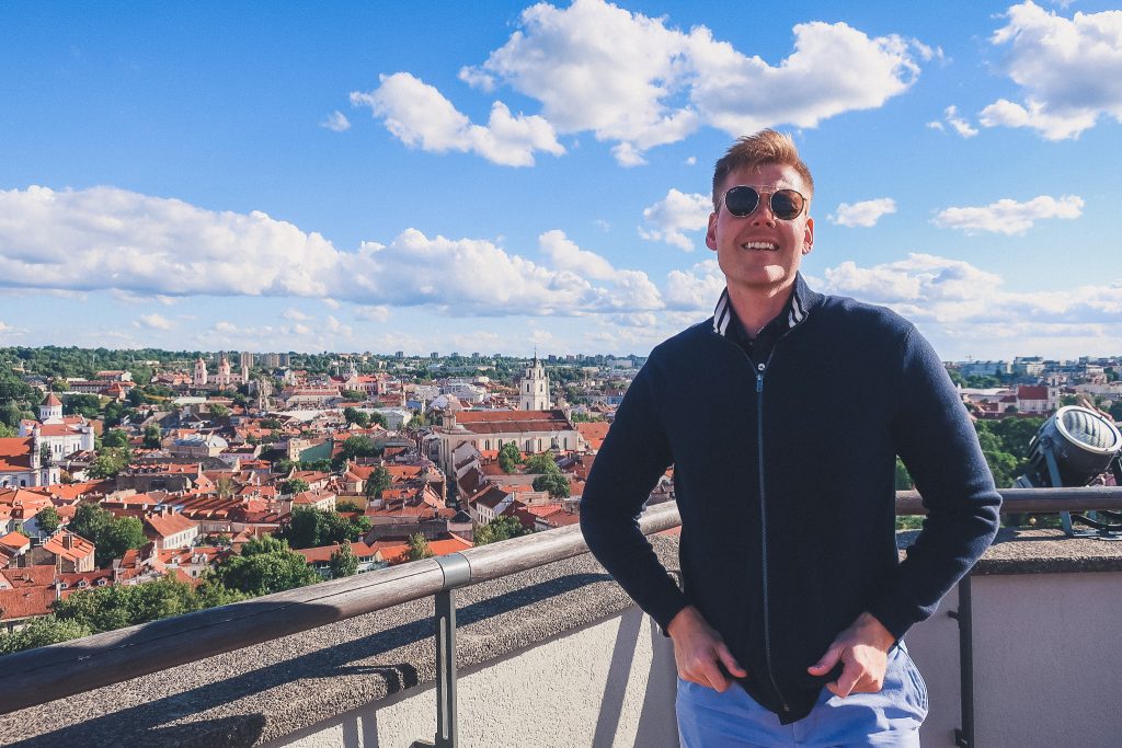 Man standing in front of Vilnius panorama at Gediminas Castle tower