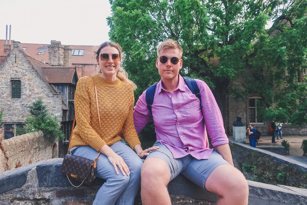 couple sits on Bonifacius Bridge in Bruges