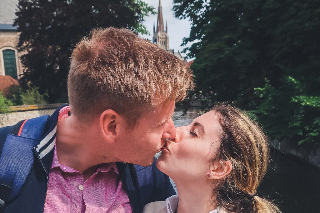 couple kissing on Lover's bridge in Bruges