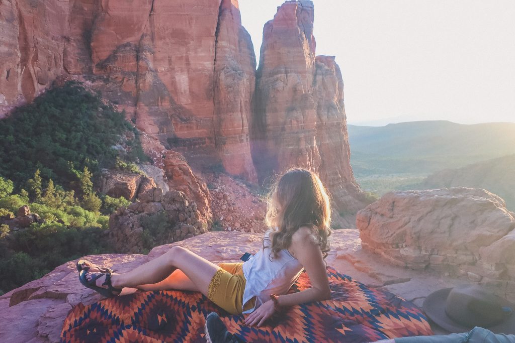 Girl watches the sunset at the top of Cathedral Rock in Sedona