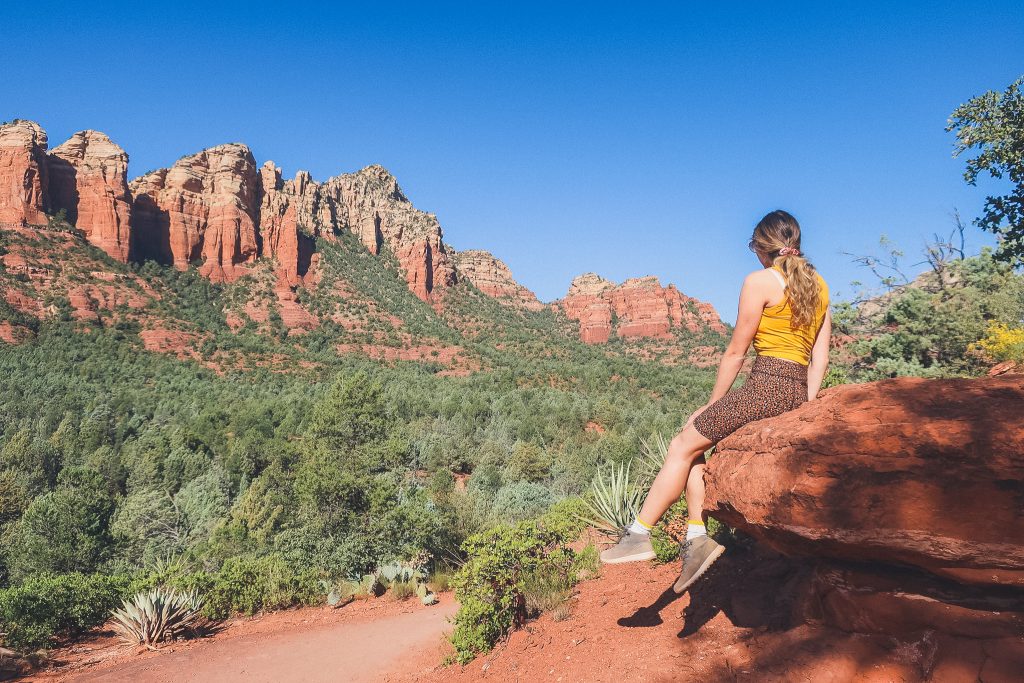 Girl looks in to the forest, she's near the Solder's Pass trail in Sedona