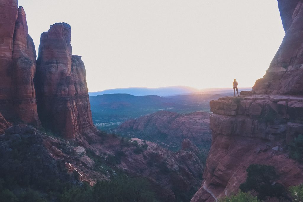 Girl watches sunset from Cathedral Rock in the distance