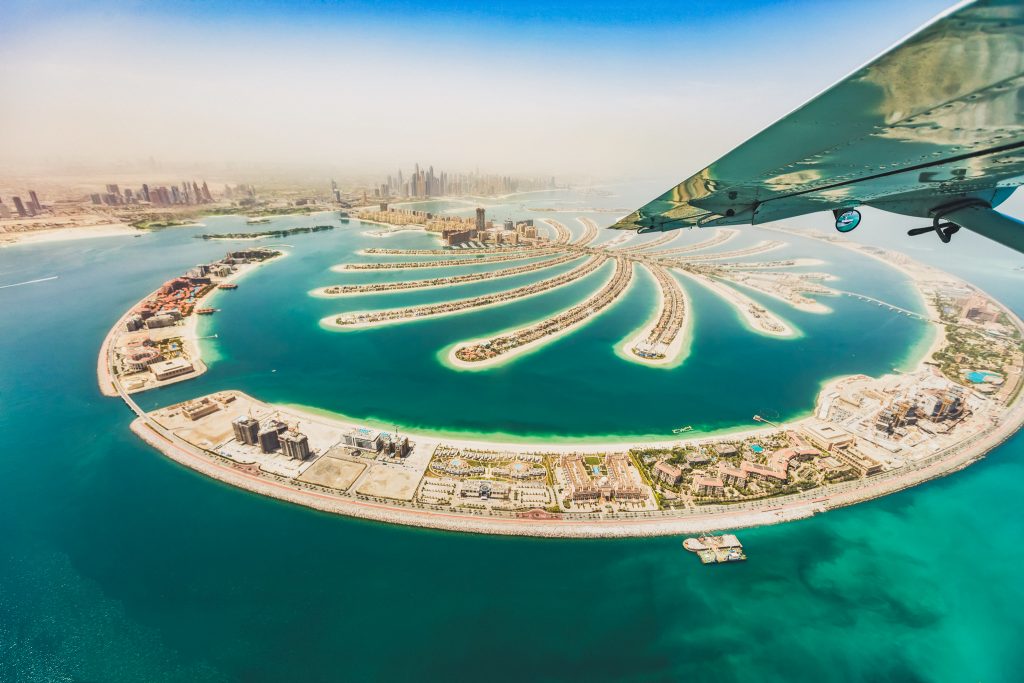 Aerial view from airplane window, artificial palm island in Dubai. Panoramic view.