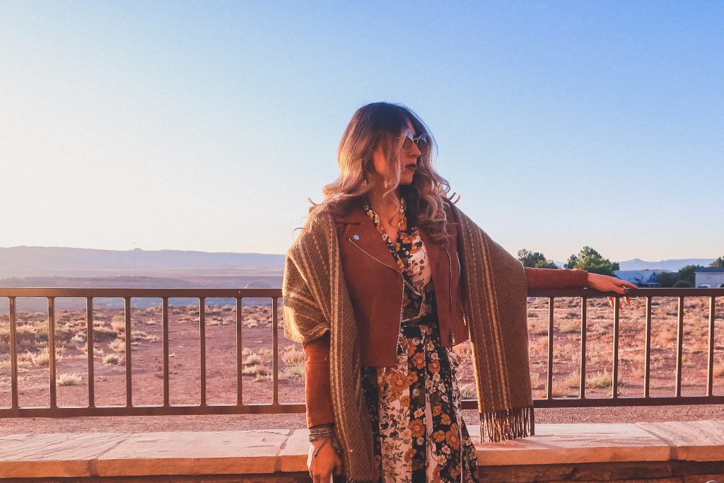 girl wears suede jacket with wool blanket scarf and flowered dress