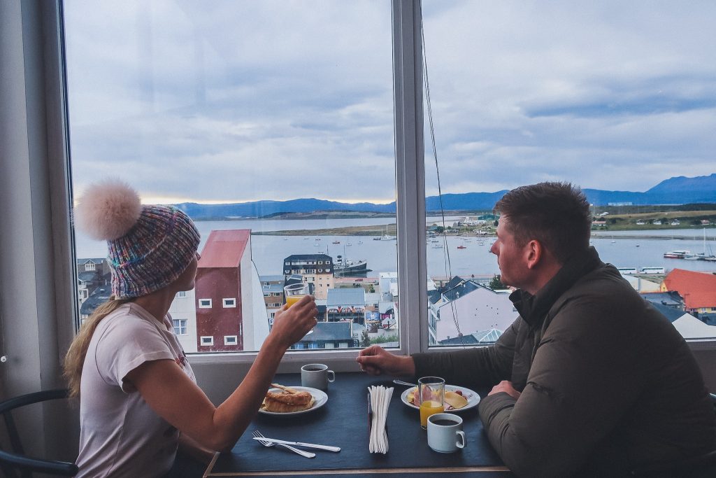 man and woman eat and restaurant, woman wears pom hat