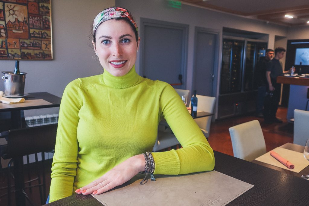 girl eats at restaurant in ushuaia, she wears a turtleneck and silky headband