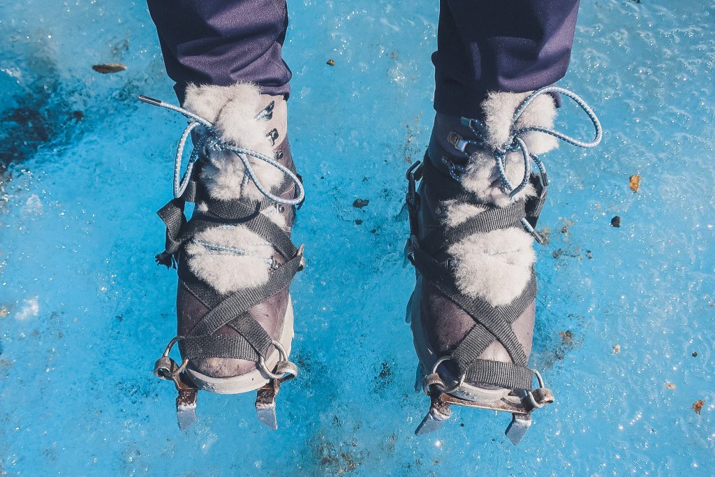 Furry snow boots inside crampons on the ice