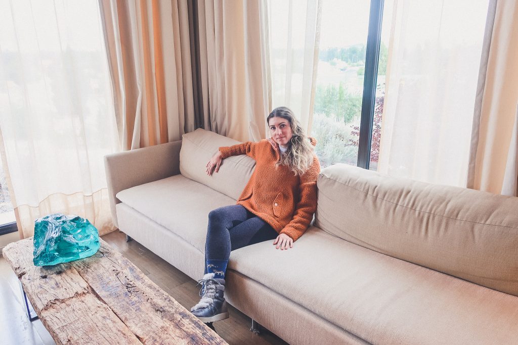 girl sits in fancy hotel lobby wearing furry snow boots 