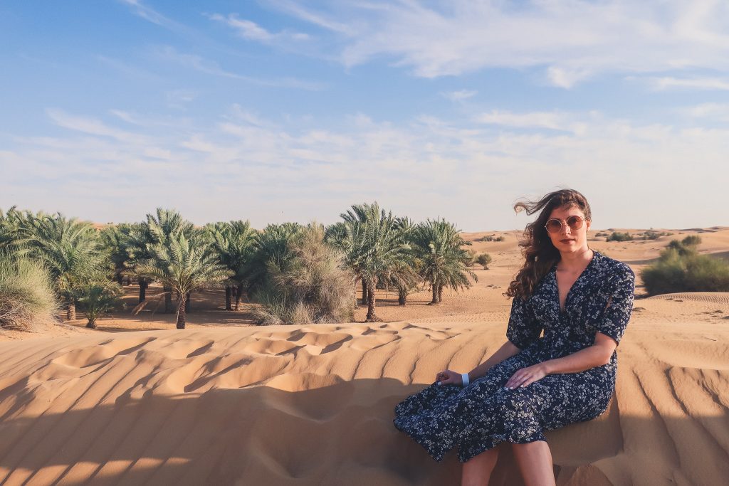 woman wears midi length dress in the desert outside of Dubai