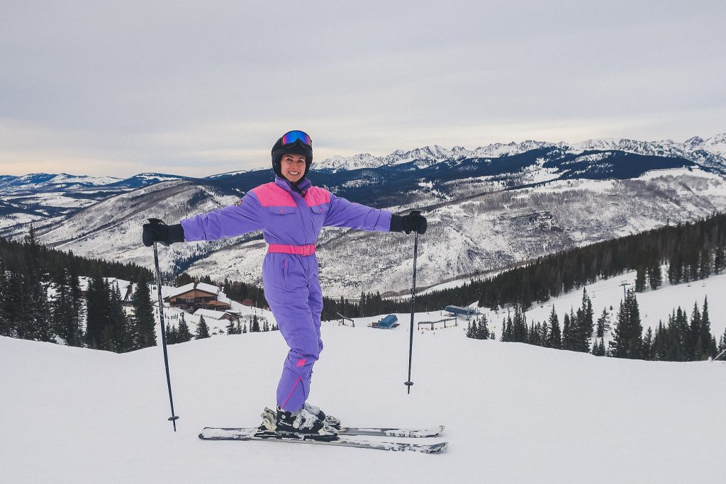 woman in Vail, CO skiing, wearing one piece snowsuit