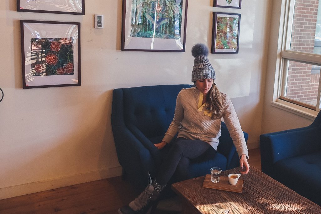 woman wears fur pom hoodie