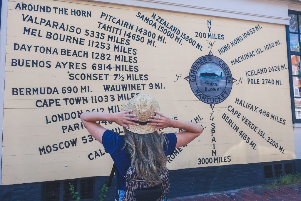 woman stands in front of compass rose in Nantucket