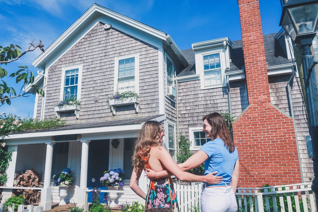 two woman walking around Sconset admiring beautiful cottages in nantucket 