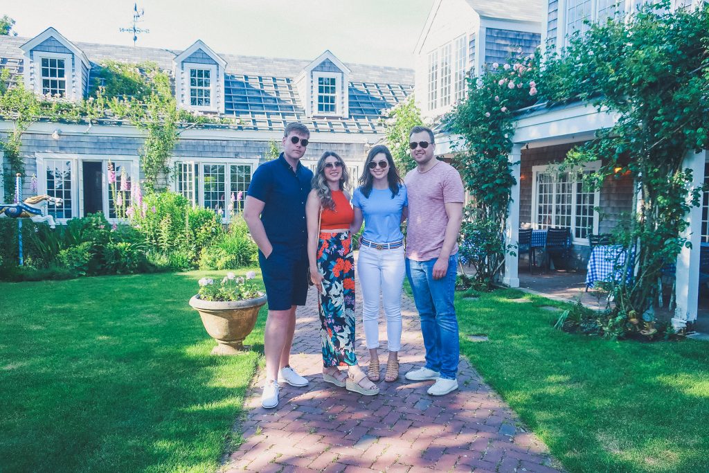 group of friends stands in garden of the The Chanticleer Nantucket