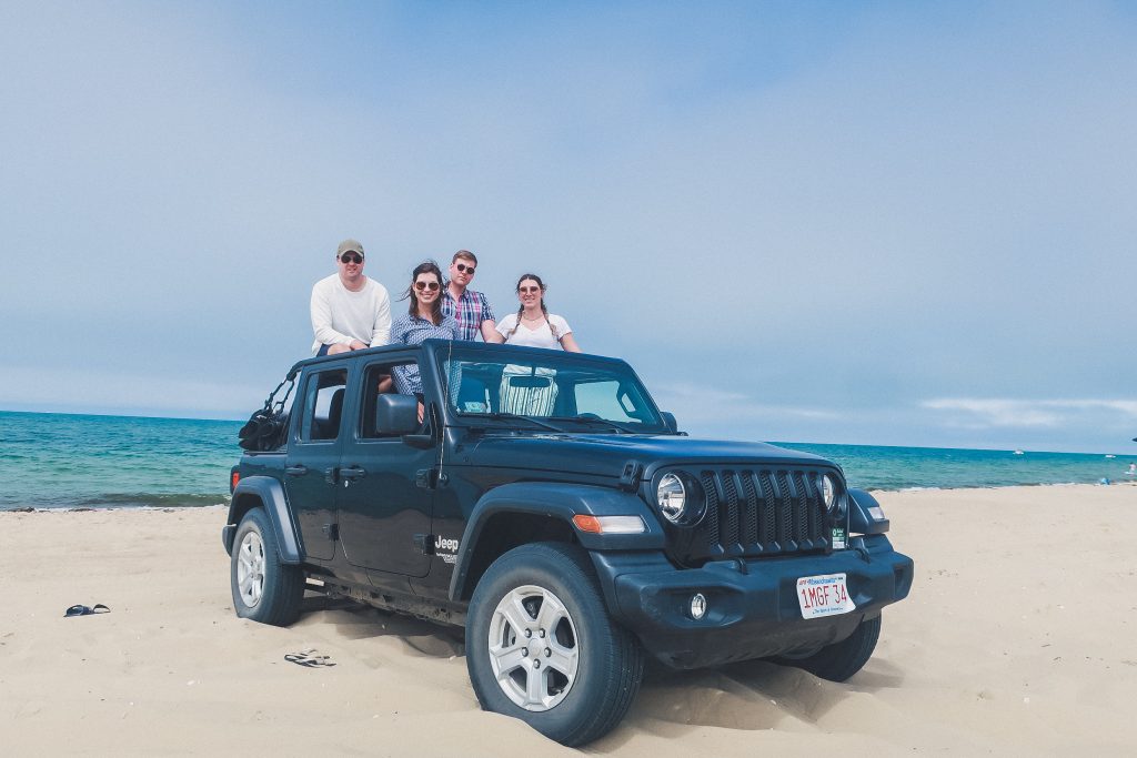 Madaket Beach, 4 friends pop out of the top of a black Jeep