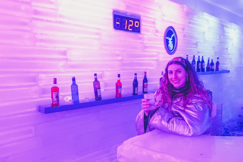 woman stands next to the thermometer at an Ice bar in El Calafate