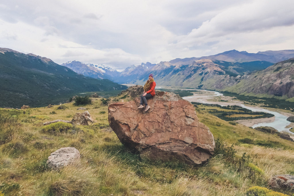 woman sits on a rock, near el chalten Argentina