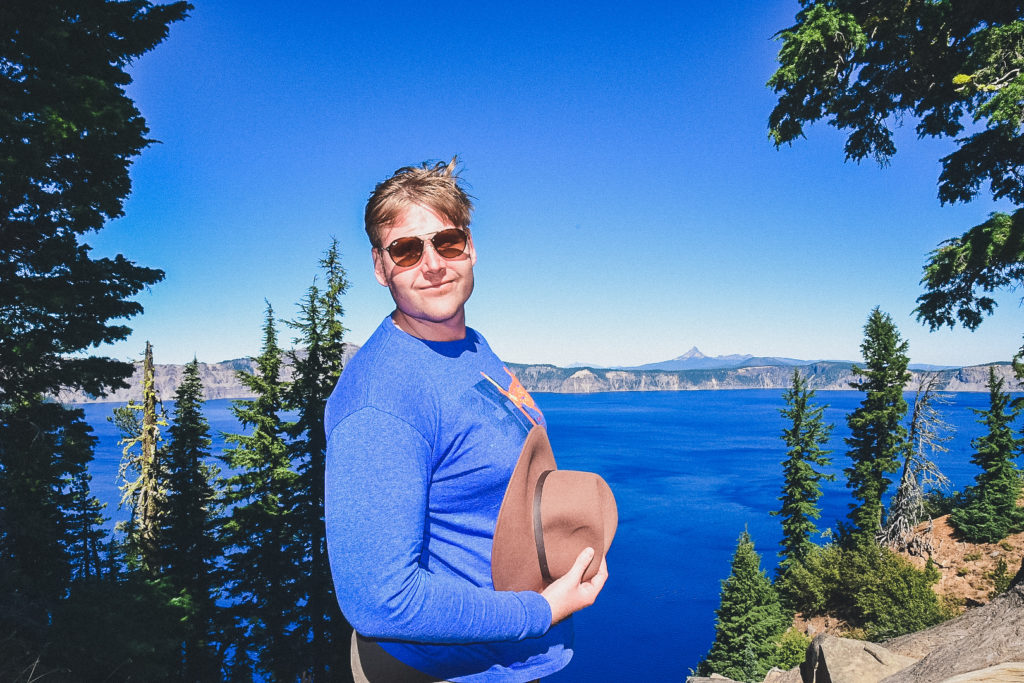 man stands in front of Crater Lake, Oregon