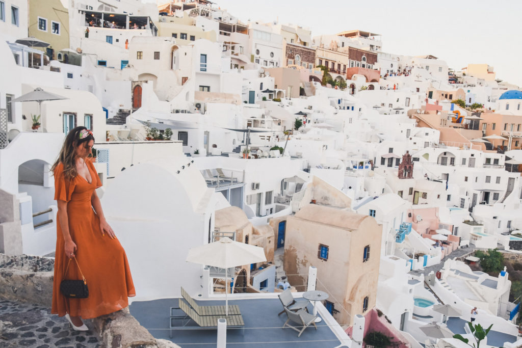 woman walks around Oia santorini