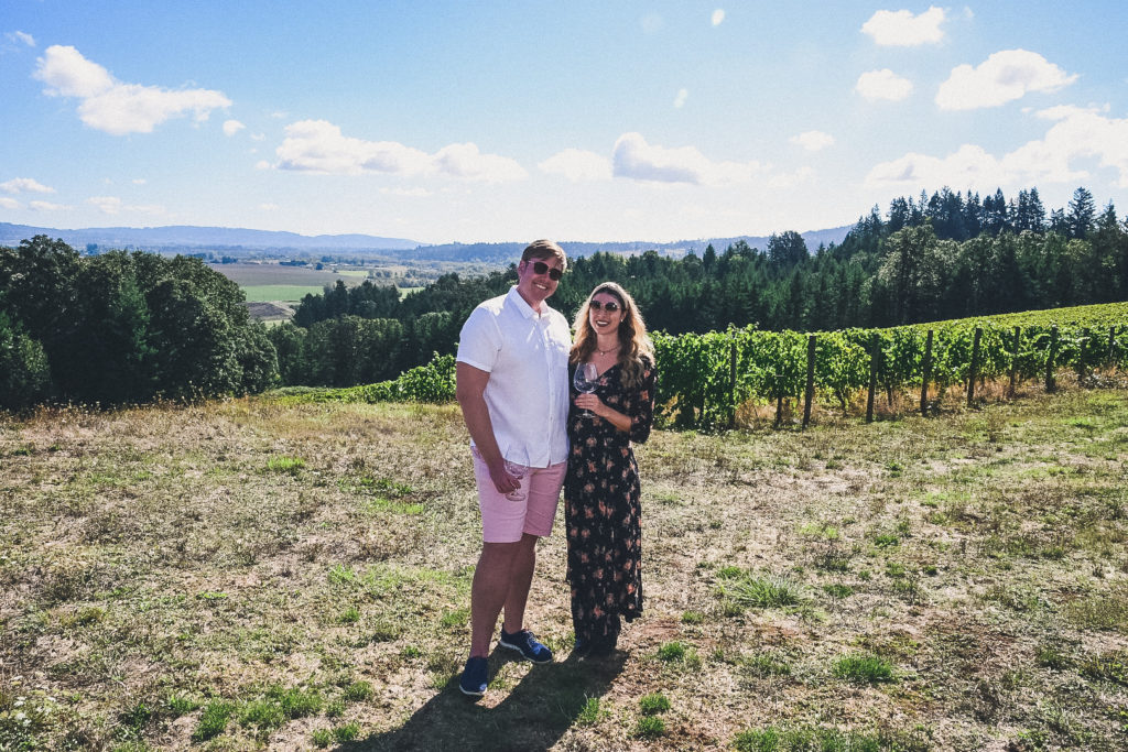 wineries in the Willamette Valley, couple in the sun with vineyards in the backgtound 